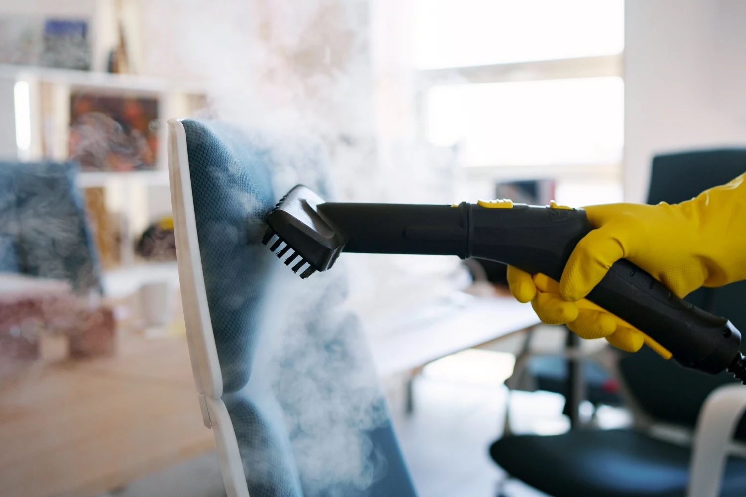 Steam cleaner nozzle being used on the upholstered back of a chair