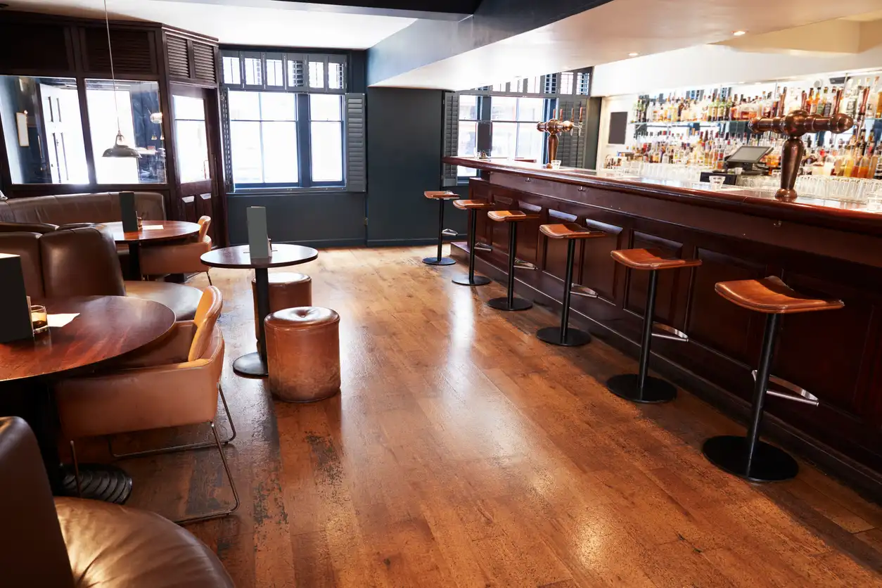 Timber bar counter with saddle stools and a clear floor route running along the front