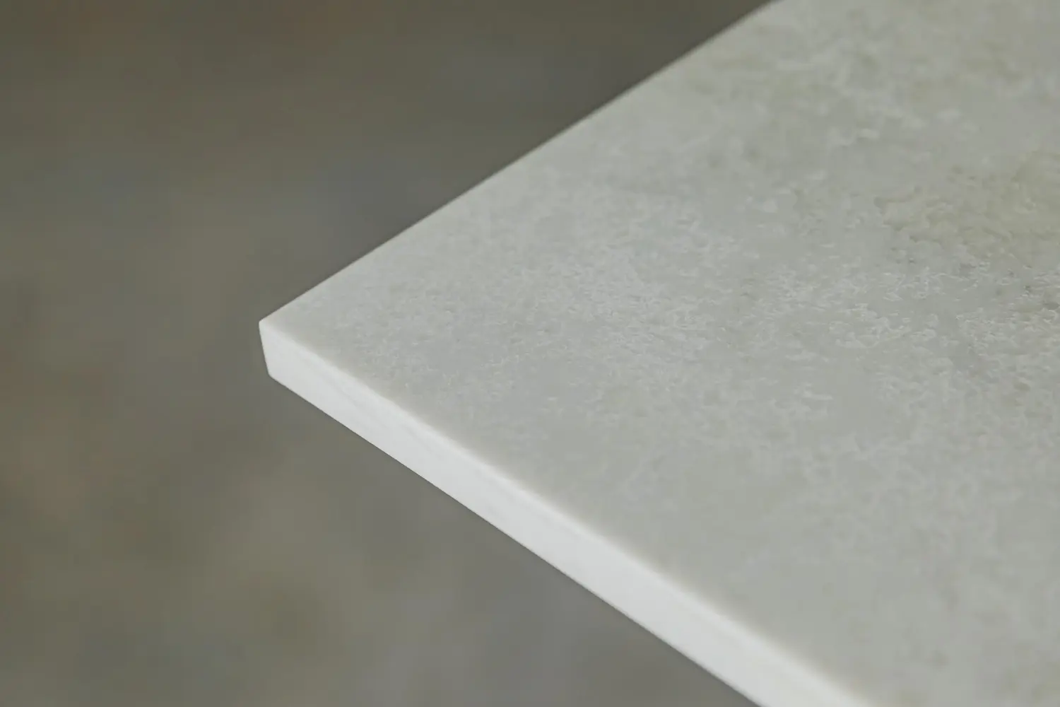Close-up of a square restaurant table top corner showing the edge profile and top thickness