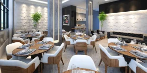 Bright restaurant interior with cream upholstered armchairs, timber tables and a dark banquette against a textured wall