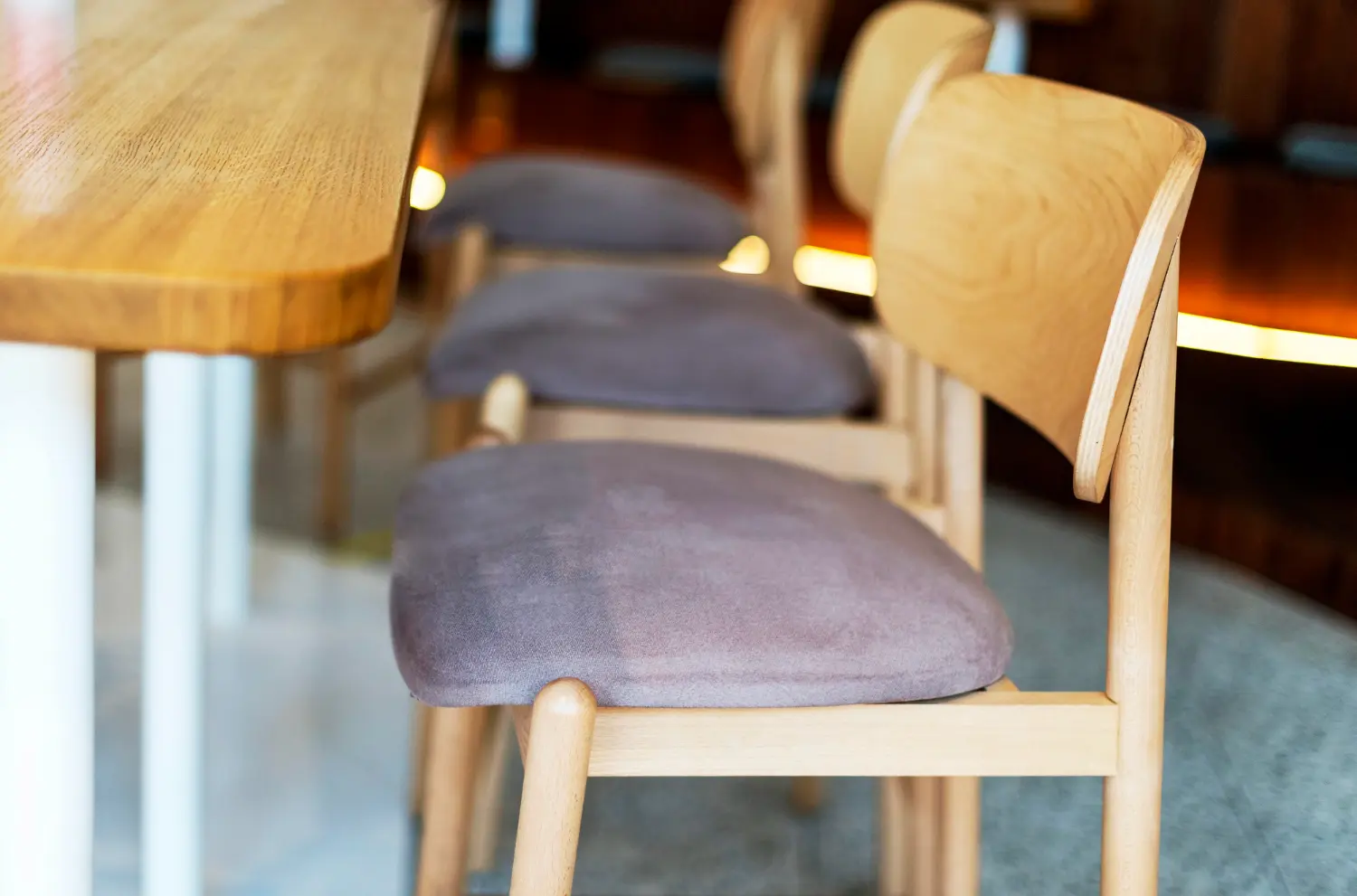 Restaurant chair lifespan in practice: timber frames still tight while the grey seat pads show wear